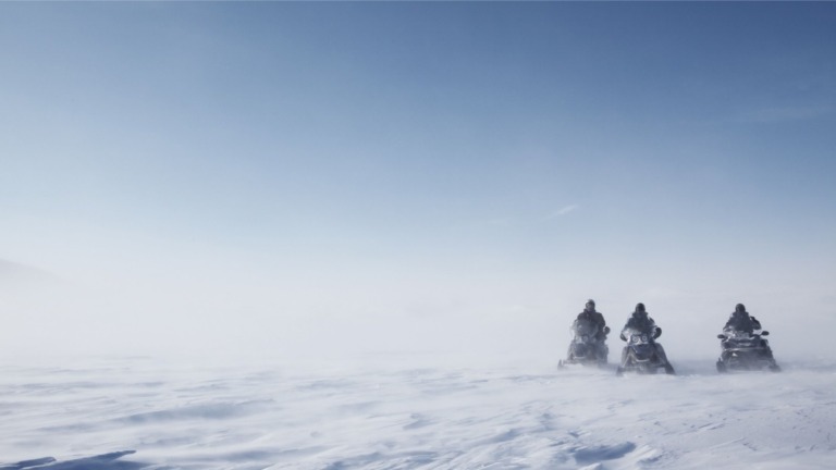 Snowmobile drivers exploring Svalbard.