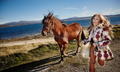 Mari Boine running with a horse on a beach