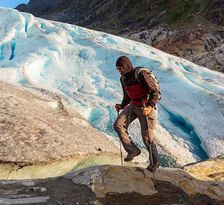 Person hiking near a glacier in Norway.