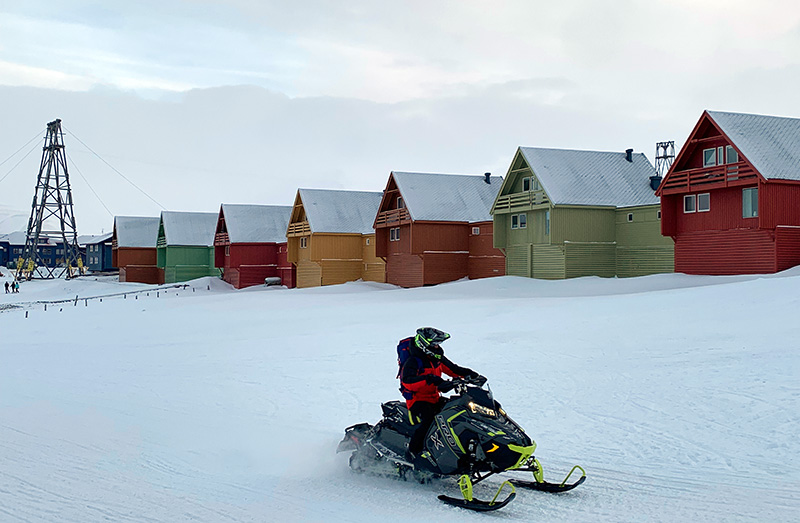 Person riding a snowscooter in Longyearbyen. Photo: David Nikel.