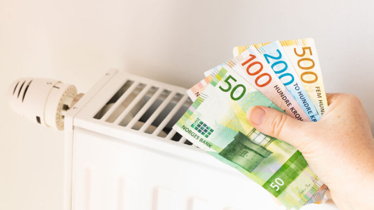 Norwegian krone banknotes in front of a radiator.