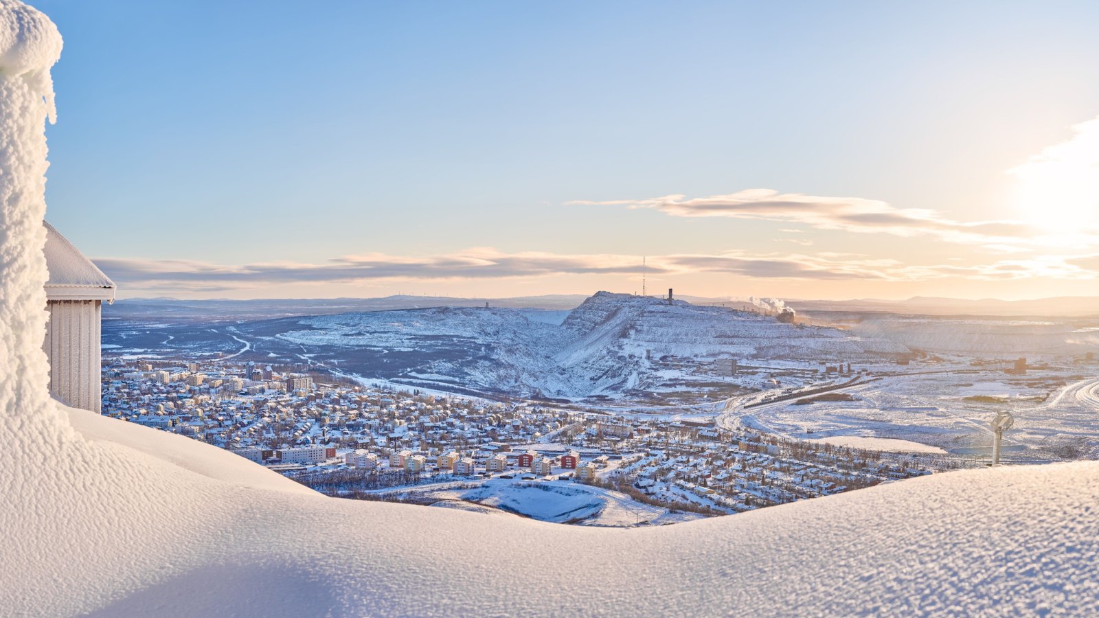 View of Kiruna and the iron ore mine seen from the snowy mountain peak Luossavaara.