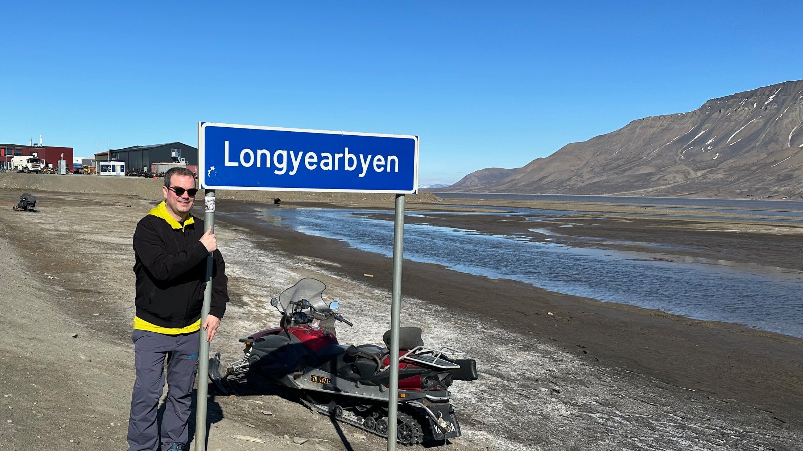 David standing by the Longyearbyen town sign in the summer. Photo: David Nikel.