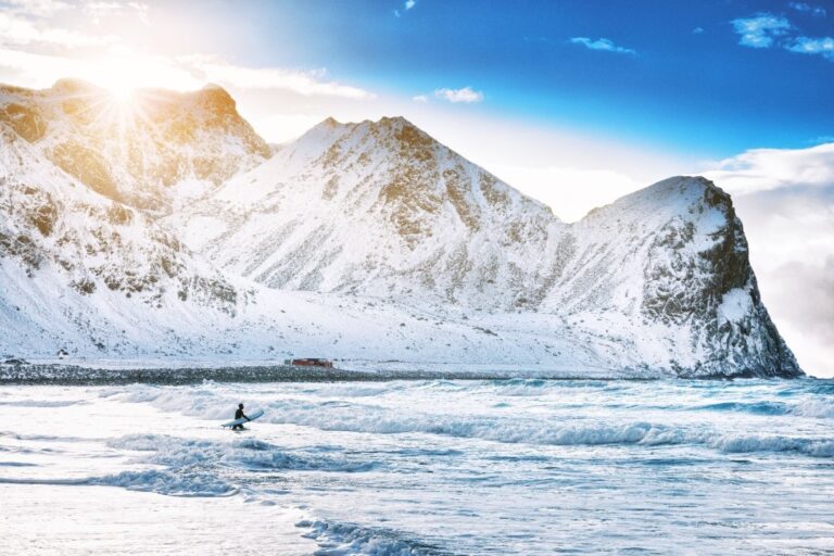 A surfer at Unstad Beach in the winter.